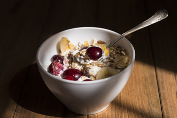 Bowl of yogurt with muesli and fruits.