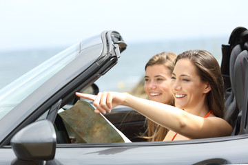 Happy tourists in a car consulting guide on vacations