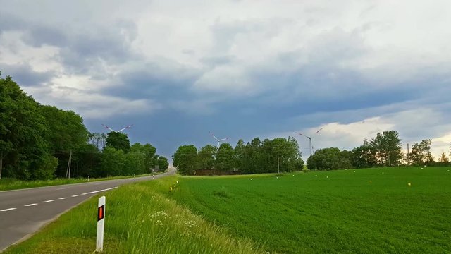 Windmills rotate blades over arable fields and farmland. Electric wind generators produce environmentally clean electricity using wind power. Taurage district, Lithuania, European Union
