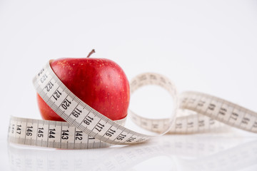 Red Apple and a Tape Measure Isolated on White Background. Concept of Diet and Healthy Food.