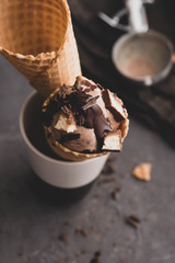 Homemade chocolate ice cream in waffle cones and pieces of dark chocolate.Toned image.