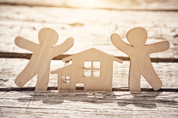 little wooden men and house on natural background. Symbol of construction, family, sweet home concept