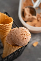 Homemade chocolate ice cream in waffle cones and pieces of dark chocolate 