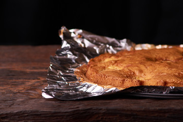 Apricot cake baked in foil on a wooden table. tasty pie food photo