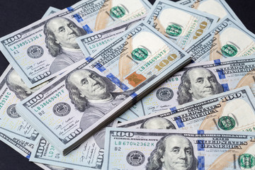 Cash of hundred dollar bills, dollar background.