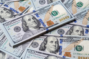 Cash of hundred dollar bills, dollar background.