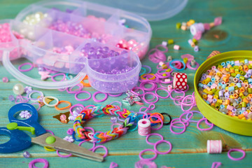 Accessories for creativity on the table. Beads, scissors and colored rubber bands.