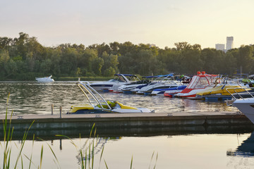Obraz premium Floating crafts on the mooring berth for summer weekend or vacation. Dnieper River, Ukraine.