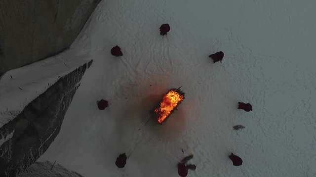 group of monks near the fire in the mountains at dusk, top view. Footage