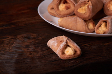 Homemade buns stuffed with cottage cheese on a wooden background. Macro photo. Selective focus.
