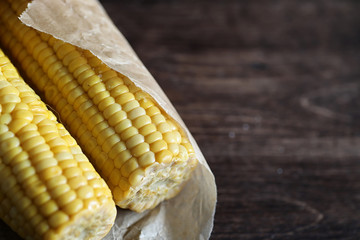 Boiled corn cob with salt on a wood