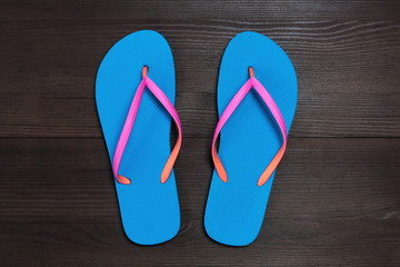 Blue flip flops isolated on wooden background. Top view