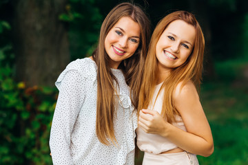 happy girls with a gentle make-up look into the camera lens and smile