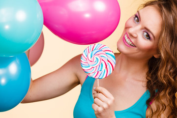 Woman with colorful balloons and lollipop
