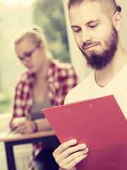 Student guy in front of her mates in classroom