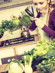 Woman looking through magnifier at vegetables basket