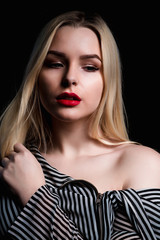 Closeup shot of young model with red lips and long hair posing with naked shoulders