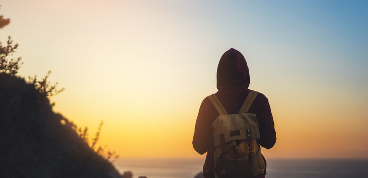 tourist traveler with backpack on morning relax time, hiker looking on sunset to valley in trip, hipster young girl enjoying peak of mountain background evening seascape ocean horizon, relax