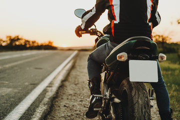 Man starting riding on motorcycle from roadside