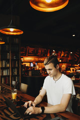 Man working on laptop sitting in bar