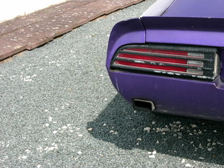 Rücklicht und Spoilerlippe am Heck eines lila Muscle Car  und Sportwagen der Siebzigerjahre auf...