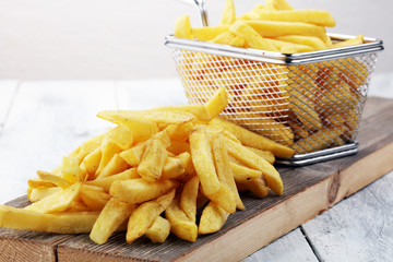 Tasty french fries on wooden table background