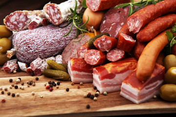 Food tray with delicious salami, ham,  fresh sausages, cucumber and herbs. Meat platter