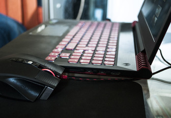 A red-black gaming laptop with a luminous keyboard © mr2853