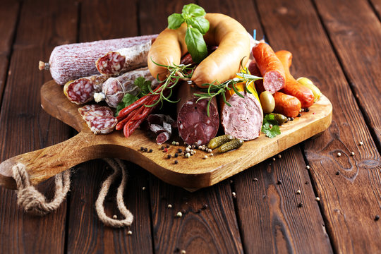 Food tray with delicious salami, ham,  fresh sausages, cucumber and herbs. Meat platter