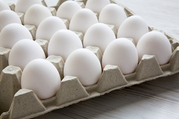 Chicken eggs in carton egg box, closeup. Side view.