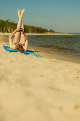 Fototapeta na wymiar Woman in bikini sunbathing and relaxing on beach