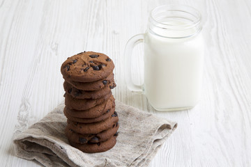 Side view chocolate cookies with milk. White wooden background. Closeup.