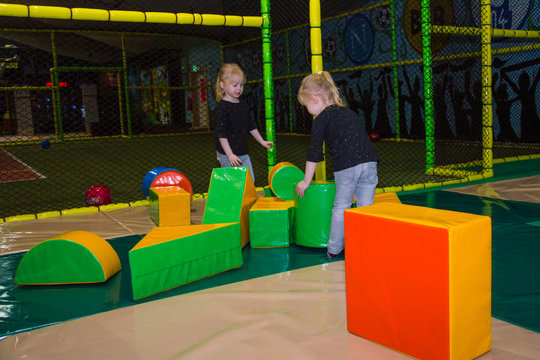 children on the playground build a tower of large paralon cubes