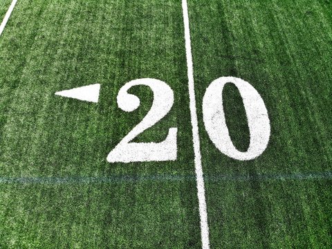 20 yard chalk mark on an green American football field taken from an aerial drone