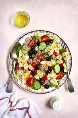 Pasta salad with tuna, cherry tomatoes, cucumber, black olives and boiled eggs.Top view.