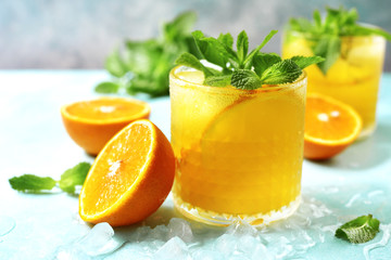 Cold summer orange lemonade with mint and ice cubes.