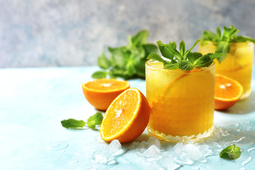 Cold summer orange lemonade with mint and ice cubes. - obrazy, fototapety, plakaty