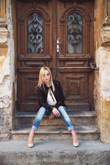 Fototapeta na wymiar Young woman in leather jacket and denim pants outdoor