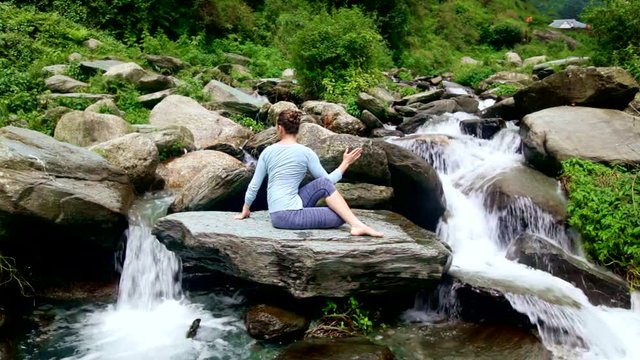 Woman doing Ardha matsyendrasana asana outdoors