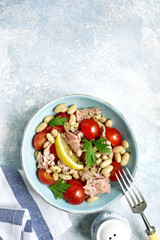 Tuna salad with cherry tomatoes and white bean.Top view with copy space.