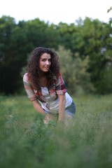 Naklejka na ściany i meble Young, beautiful woman on nature. Young woman with dark curly hair.