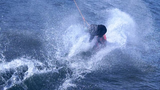 Extreme man studying riding wakeboarding stunt on water. Sportsman training jumping from springboard during wakeboarding tricks. Extreme water sports. Water sports competition. Extreme lifestyle