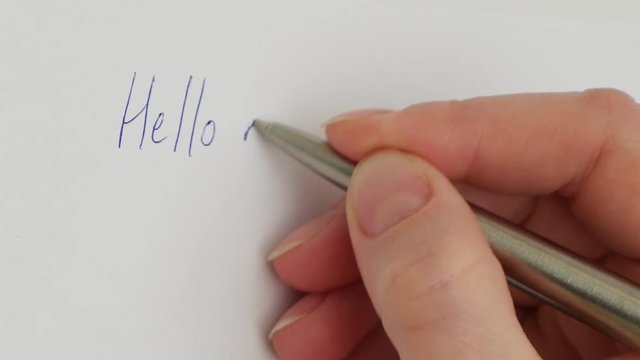 Female hand writes My dear friend on the sheet of white paper. Macro close-up shot. Vertical format video.