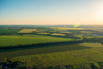Top view, aerial photo from drone or aerostat to summer nature landscape panorama, green meadows in countryside at sunset time, beautiful travel background