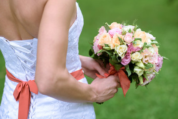 Obraz na płótnie Canvas Beautiful bride is holding a wedding colorful bouquet