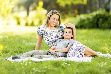 Mother and son sitting on a blanket in park
