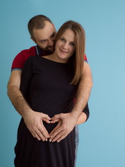 pregnant couple  isolated over blue background