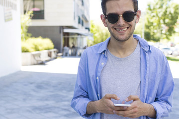 young man with mobile phone in the street