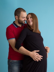 pregnant couple  isolated over blue background