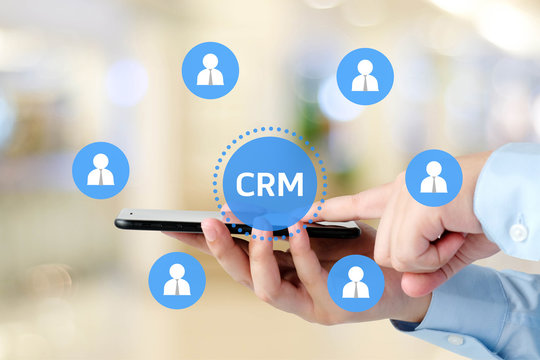 Hand using smart phone with CRM, Customer Relationship Management, icon on blur background, success in business concept